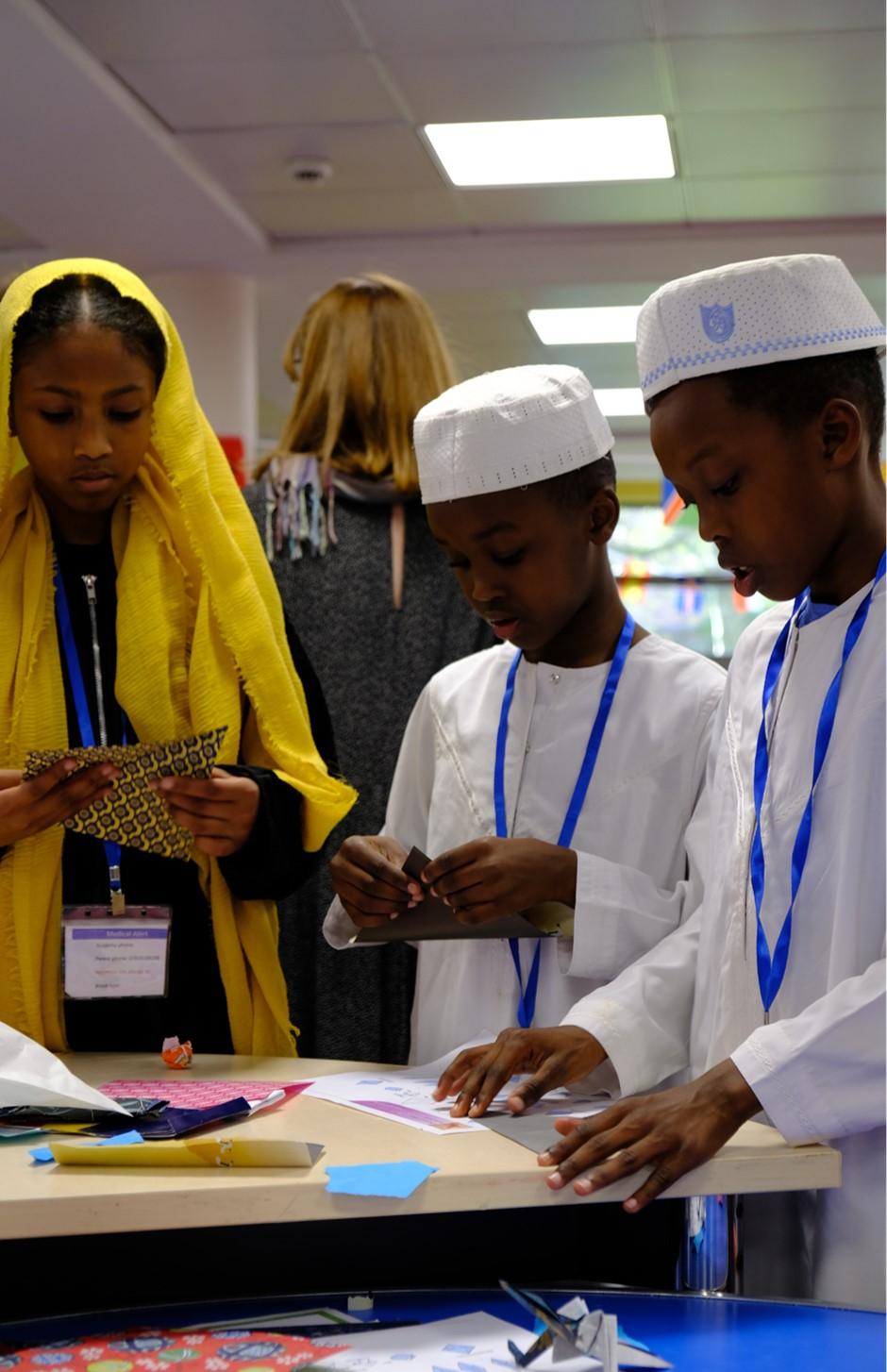 Adults and children taking part in Origami workshops. 